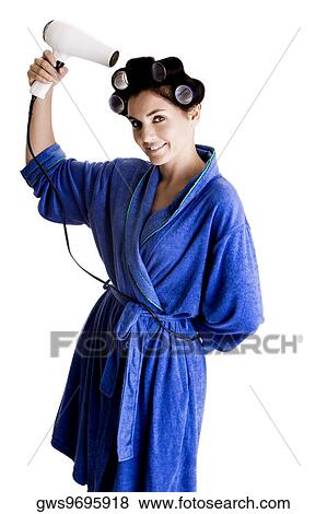 Portrait of a young woman with curlers in her hair holding a hairdryer View Large Photo Image Stock Photo - Portrait of a young woman with curlers in her hair holding a hairdryer. Fotosearch