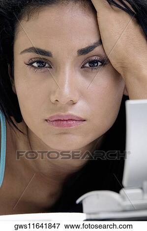 Stock Photo - Portrait of a young woman with her hand on her head. Fotosearch