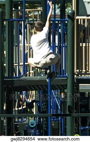 Rear view of a boy clambering on jungle gym View Large Photo Image Picture - Rear view of a boy clambering on jungle gym. Fotosearch