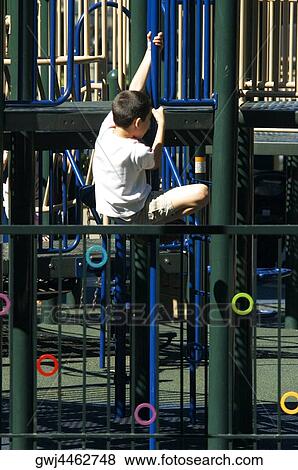 Rear view of a boy clambering on jungle gym View Large Photo Image Stock Photo - Rear view of a boy clambering on jungle gym. Fotosearch