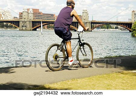Stock Image - Rear view of a person cycling. Fotosearch