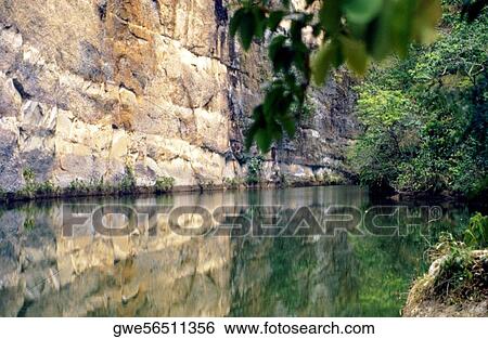 Reflection of a cliff in water View Large Photo Image Stock Photograph - Reflection of a cliff in water. Fotosearch