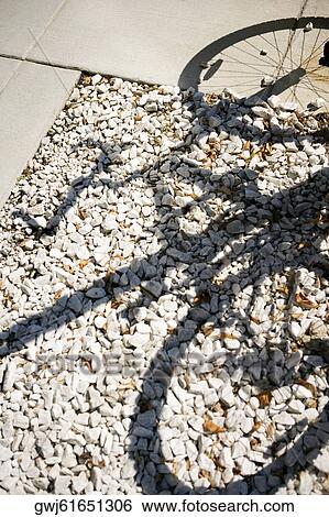Shadow of a bicycle falling on pebbles, Washington DC, USA View Large Photo Image Stock Photograph - Shadow of a bicycle falling on pebbles, Washington DC, USA. Fotosearch