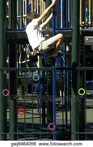 Side profile of a boy clambering on jungle gym View Large Photo Image Stock Photograph - Side profile of a boy clambering on jungle gym. Fotosearch