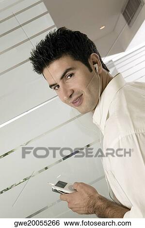 Side profile of a businessman listening to an MP3 Player View Large Photo Image Stock Photograph - Side profile of a businessman listening to an MP3 Player. Fotosearch