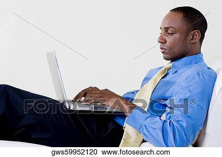 Side profile of a businessman using a laptop View Large Photo Image Stock Image - Side profile of a businessman using a laptop. Fotosearch