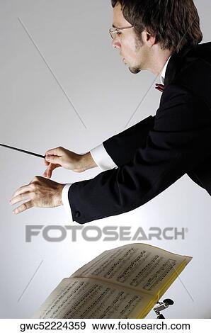 Stock Photo - Side profile of a conductor holding a baton. Fotosearch