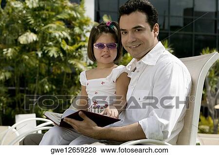 Side profile of a father sitting with his daughter View Large Photo Image Stock Photo - Side profile of a father sitting with his daughter. Fotosearch