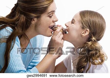 Side profile of a mother and her daughter eating a pastry View Large Photo Image Stock Image - Side profile of a mother and her daughter eating a pastry. Fotosearch
