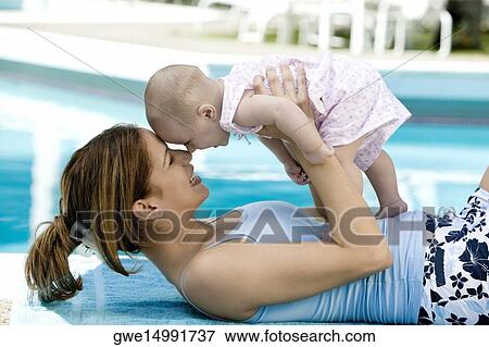 Side profile of a mother nuzzling with her baby View Large Photo Image Stock Photo - Side profile of a mother nuzzling with her baby. Fotosearch