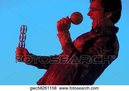 Side profile of a musician playing the maracas View Large Photo Image Stock Photo - Side profile of a musician playing the maracas. Fotosearch