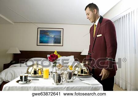 Side profile of a waiter serving food View Large Photo Image Stock Image - Side profile of a waiter serving food. Fotosearch