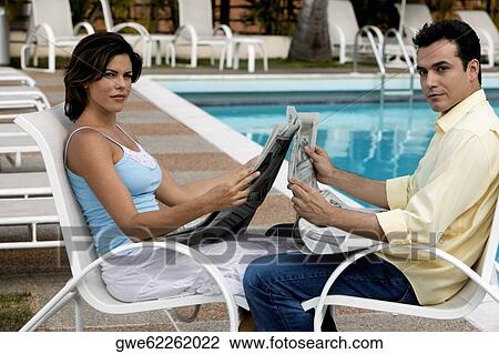 Side profile of a young couple holding a newspaper View Large Photo Image Stock Image - Side profile of a young couple holding a newspaper. Fotosearch