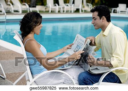 Side profile of a young couple reading a newspaper View Large Photo Image Stock Photography - Side profile of a young couple reading a newspaper. Fotosearch