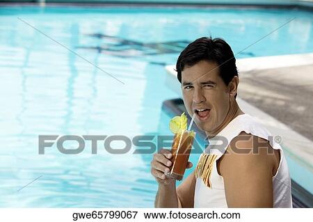 Side profile of a young man holding a glass of drink View Large Photo Image Stock Photo - Side profile of a young man holding a glass of drink. Fotosearch