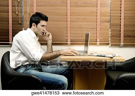 Side profile of a young man using a laptop View Large Photo Image Stock Image - Side profile of a young man using a laptop. Fotosearch