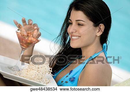 Side profile of a young woman having a meal View Large Photo Image Picture - Side profile of a young woman having a meal. Fotosearch