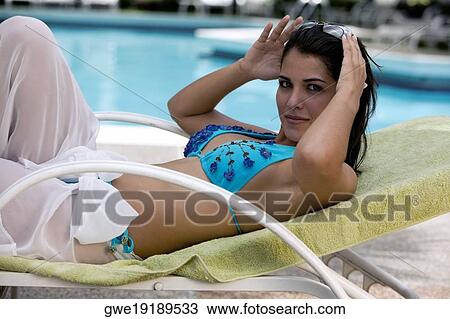 Side profile of a young woman relaxing on a lounge chair View Large Photo Image Stock Image - Side profile of a young woman relaxing on a lounge chair. Fotosearch