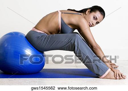 Side profile of a young woman exercising with a fitness ball View Large Photo Image Stock Image - Side profile of a young woman exercising with a fitness ball. Fotosearch