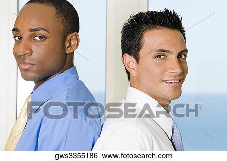 Stock Photograph - Side profile of two businessmen back to back. Fotosearch