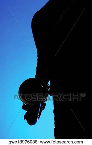Stock Photo - Silhouette of a musician holding a saxophone. Fotosearch
