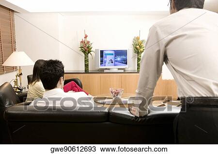 Stock Image - Three people watching television. Fotosearch