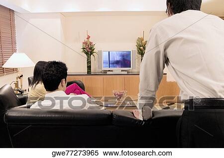 Three people watching television View Large Photo Image Stock Photography - Three people watching television. Fotosearch