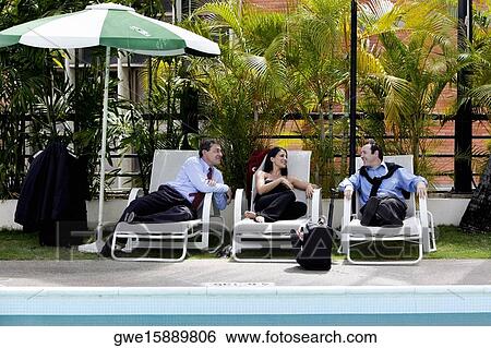 Stock Photograph - Two businessmen and a businesswoman talking. Fotosearch