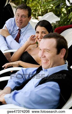 Stock Photograph - Two businessmen and a businesswoman smiling. Fotosearch
