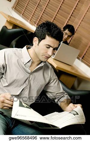 Two young businessmen working in office View Large Photo Image Stock Photograph - Two young businessmen working in office. Fotosearch
