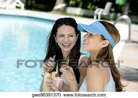 Two young women holding glasses View Large Photo Image Stock Image - Two young women holding glasses. Fotosearch