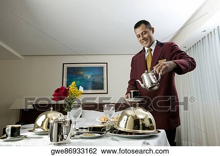 Waiter pouring tea in a cup View Large Photo Image Stock Image - Waiter pouring tea in a cup. Fotosearch