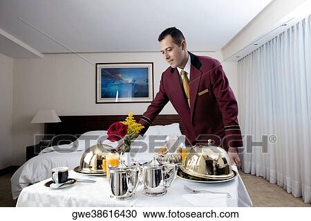 Stock Image - Waiter serving food. Fotosearch