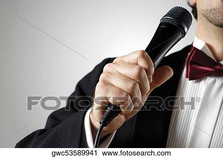 Stock Image - Young man holding a microphone. Fotosearch