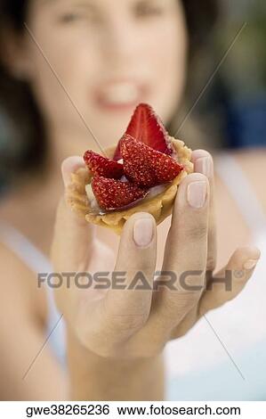Young woman holding a cupcake View Large Photo Image Stock Photograph - Young woman holding a cupcake. Fotosearch