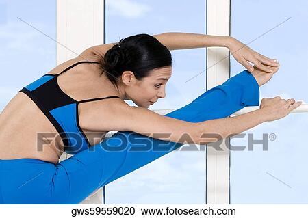 Young woman stretching her legs View Large Photo Image Stock Image - Young woman stretching her legs. Fotosearch