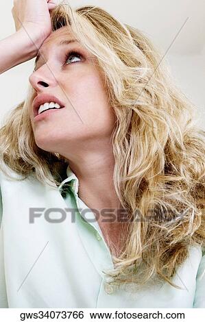 Young woman with her hand on her head View Large Photo Image Stock Photograph - Young woman with her hand on her head. Fotosearch