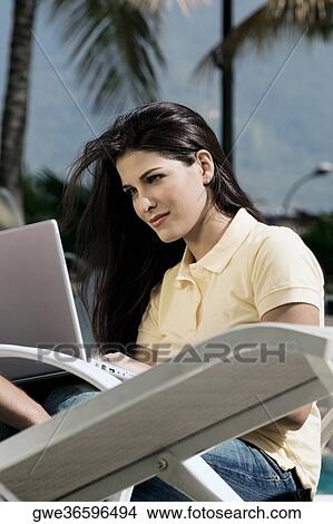 Young woman working on a laptop View Large Photo Image Picture - Young woman working on a laptop. Fotosearch