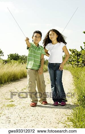Boy and a girl standing in a walkway View Large Photo Image Stock Image - Boy and a girl standing in a walkway. Fotosearch