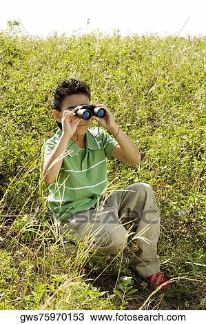 Boy looking through a pair of binoculars View Large Photo Image Stock Image - Boy looking through a pair of binoculars. Fotosearch