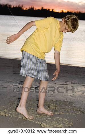 Stock Image - Boy playing on the beach. Fotosearch