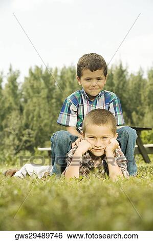 Boy riding on his friend's back View Large Photo Image Stock Photograph - Boy riding on his friend's back. Fotosearch