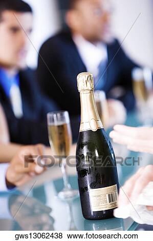 Champagne flutes and a champagne bottle on a bar counter View Large Photo Image Stock Photo - Champagne flutes and a champagne bottle on a bar counter. Fotosearch