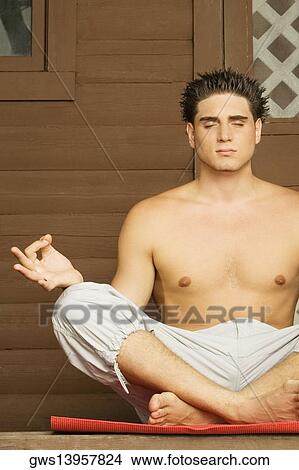 Close-up of a bare chested young man sitting in a lotus position and meditating View Large Photo Image Picture - Close-up of a bare chested young man sitting in a lotus position and meditating. Fotosearch