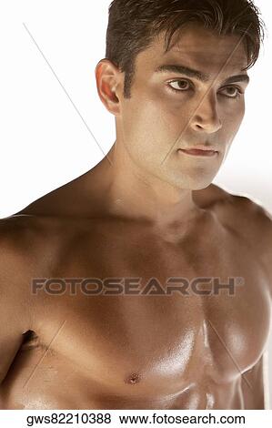 Close-up of a bare chested young man looking serious View Large Photo Image Stock Photo - Close-up of a bare chested young man looking serious. Fotosearch