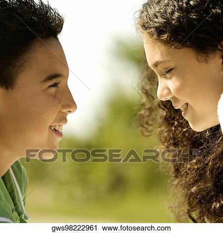 Close-up of a boy and a girl looking at each other smiling View Large Photo Image Stock Image - Close-up of a boy and a girl looking at each other smiling. Fotosearch