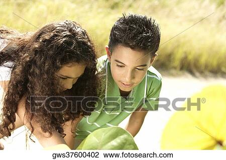 Close-up of a boy and a girl looking down View Large Photo Image Stock Image - Close-up of a boy and a girl looking down. Fotosearch