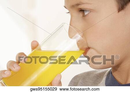 Stock Photo - Close-up of a boy drinking a glass of juice. Fotosearch