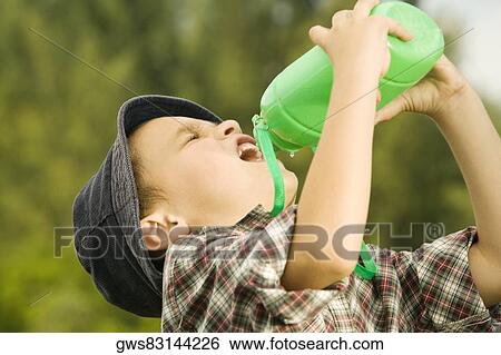 Close-up of a boy drinking water from a water bottle View Large Photo Image Stock Photograph - Close-up of a boy drinking water from a water bottle. Fotosearch