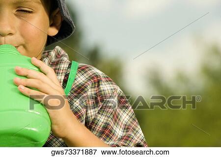 Close-up of a boy drinking water View Large Photo Image Stock Photo - Close-up of a boy drinking water. Fotosearch